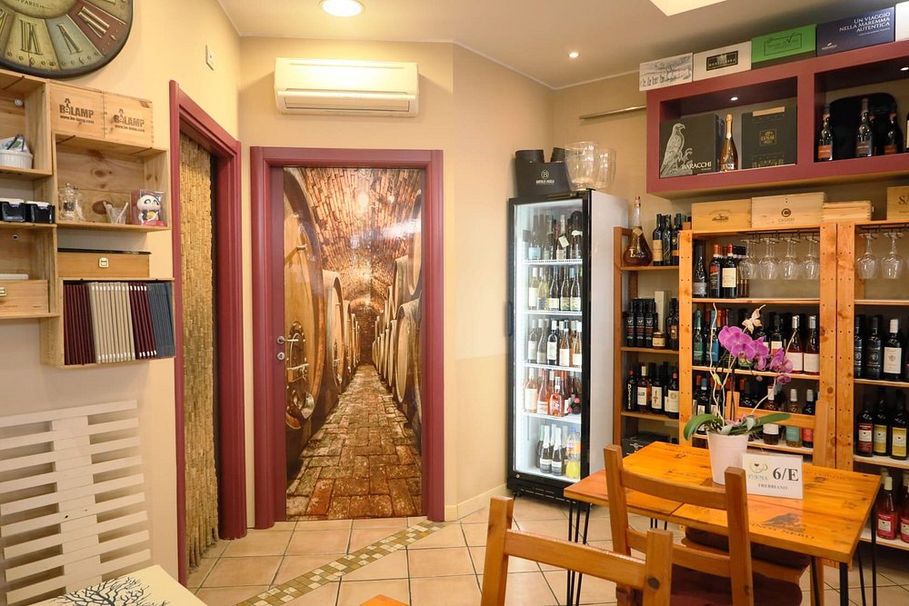 Particolare dell'enoteca: porta con trompe l'oeil e bottiglie